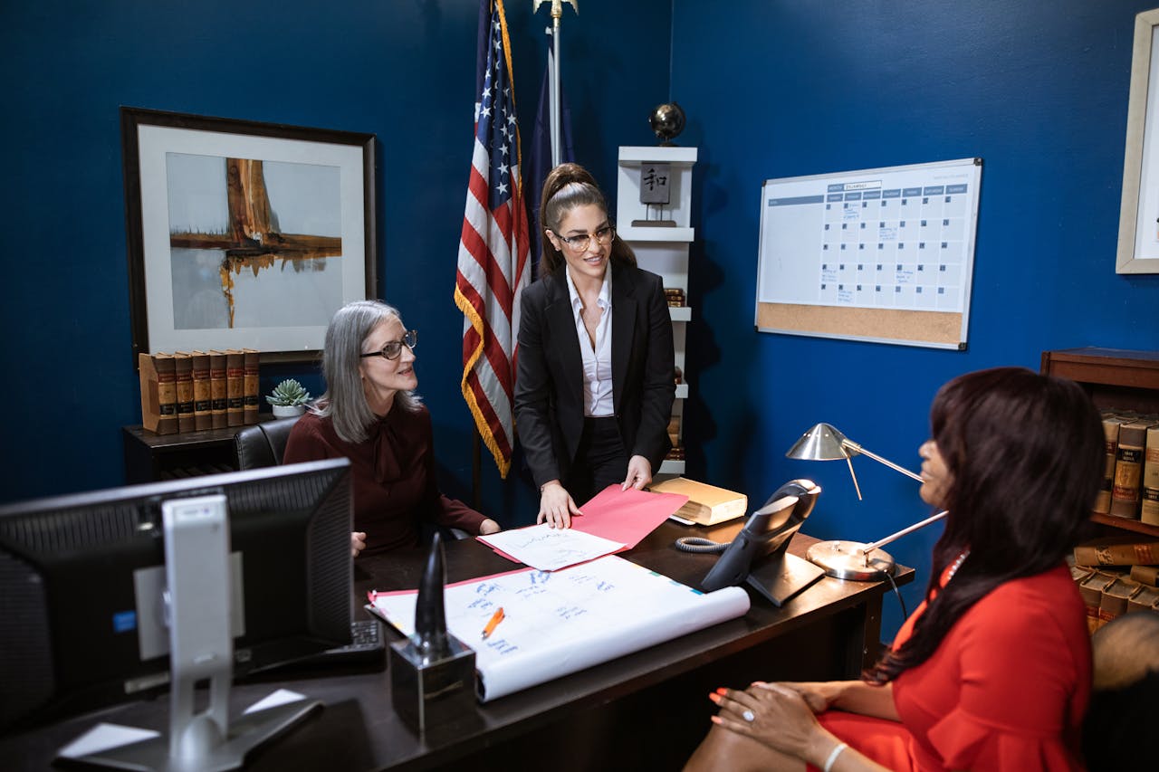 Crafting Captivating Headlines: Your awesome post title goes here Three professional women in a business meeting discussing paperwork in a well-appointed office.