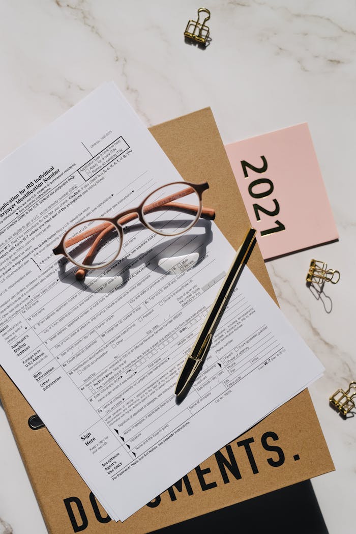 The Art of Drawing Readers In: Your attractive post title goes here Close-up of tax forms, glasses, and pen on a desk, perfect for financial content.